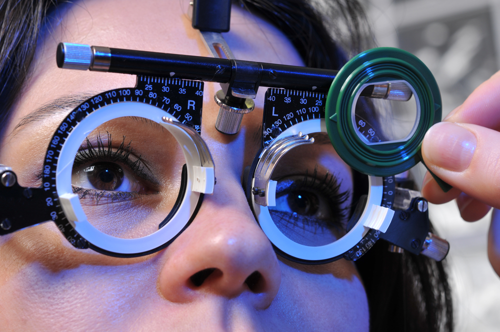 Close-up of a patient’s eyes during a detailed eye exam using trial frames and magnifying lens, representing accurate vision assessment and professional optometry care – eye exam plymouth