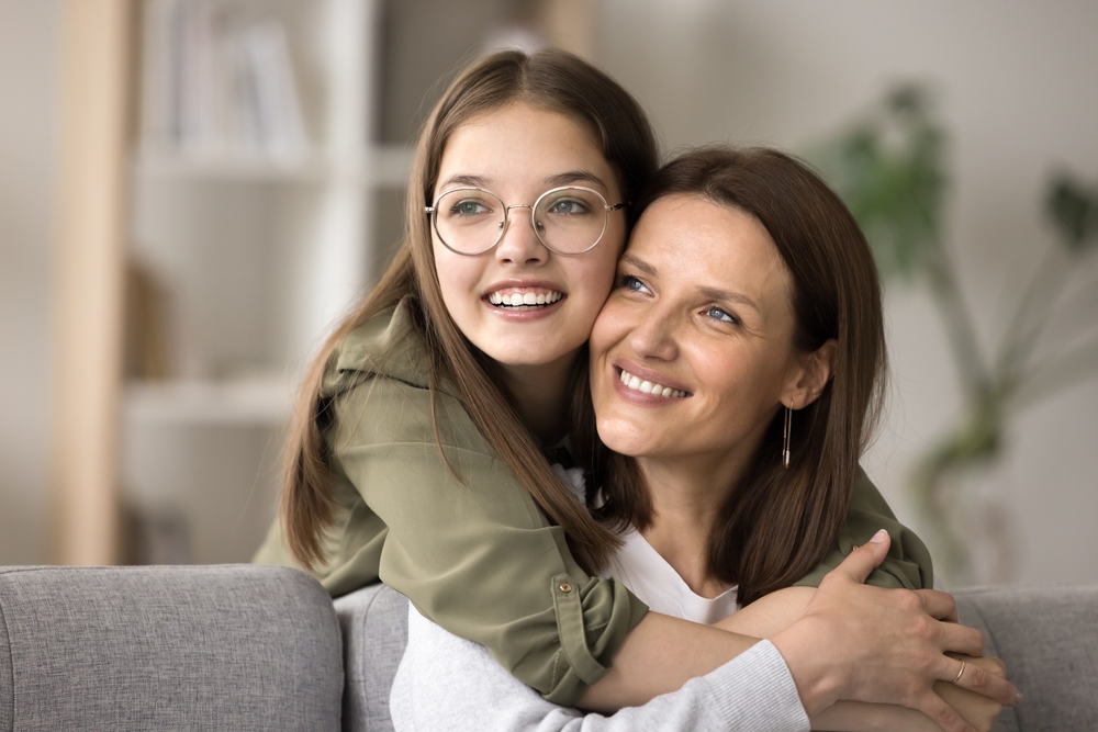 Smiling mother and daughter embracing at home, symbolizing trust, comfort, and compassionate vision care for the whole family – otsego eye doctor