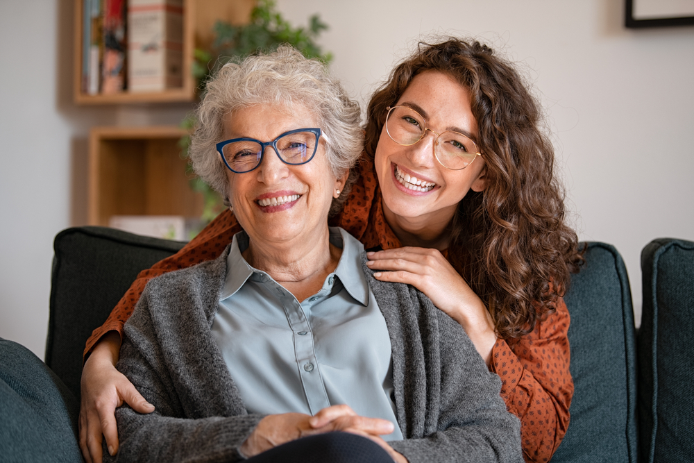 Happy senior woman wearing glasses seated with a younger woman smiling beside her, symbolizing trust, comfort, and family-centered eye care – Eye Doctor Plymouth